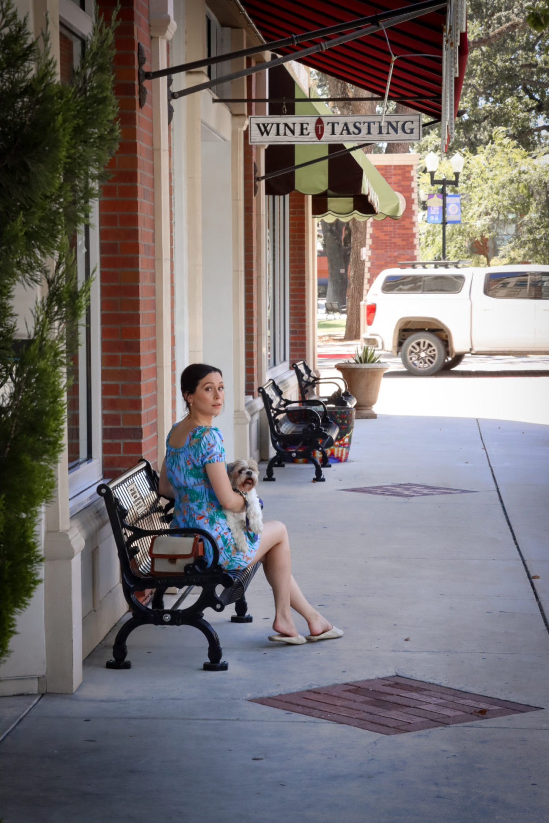 Travel Blogger Jordan Gassner holding her dog, Charlie, on a bench in front while spending a day in Paso Robles, California