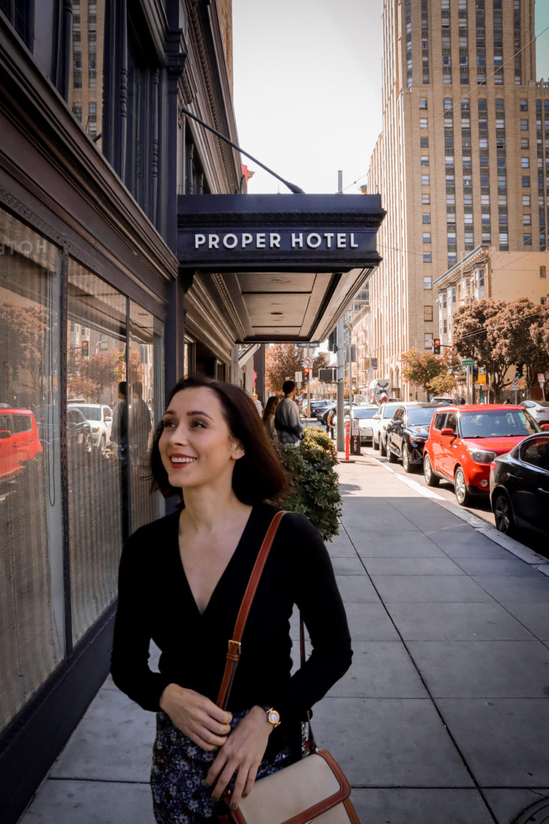Travel Blogger Jordan Gassner smiling in front of The San Francisco Proper Hotel awning