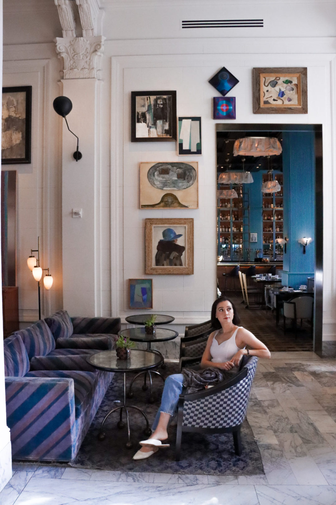 Travel Blogger Jordan Gassner blue checkered accent chair inside the Kelly Wearstler designed San Francisco Proper Hotel Lobby
