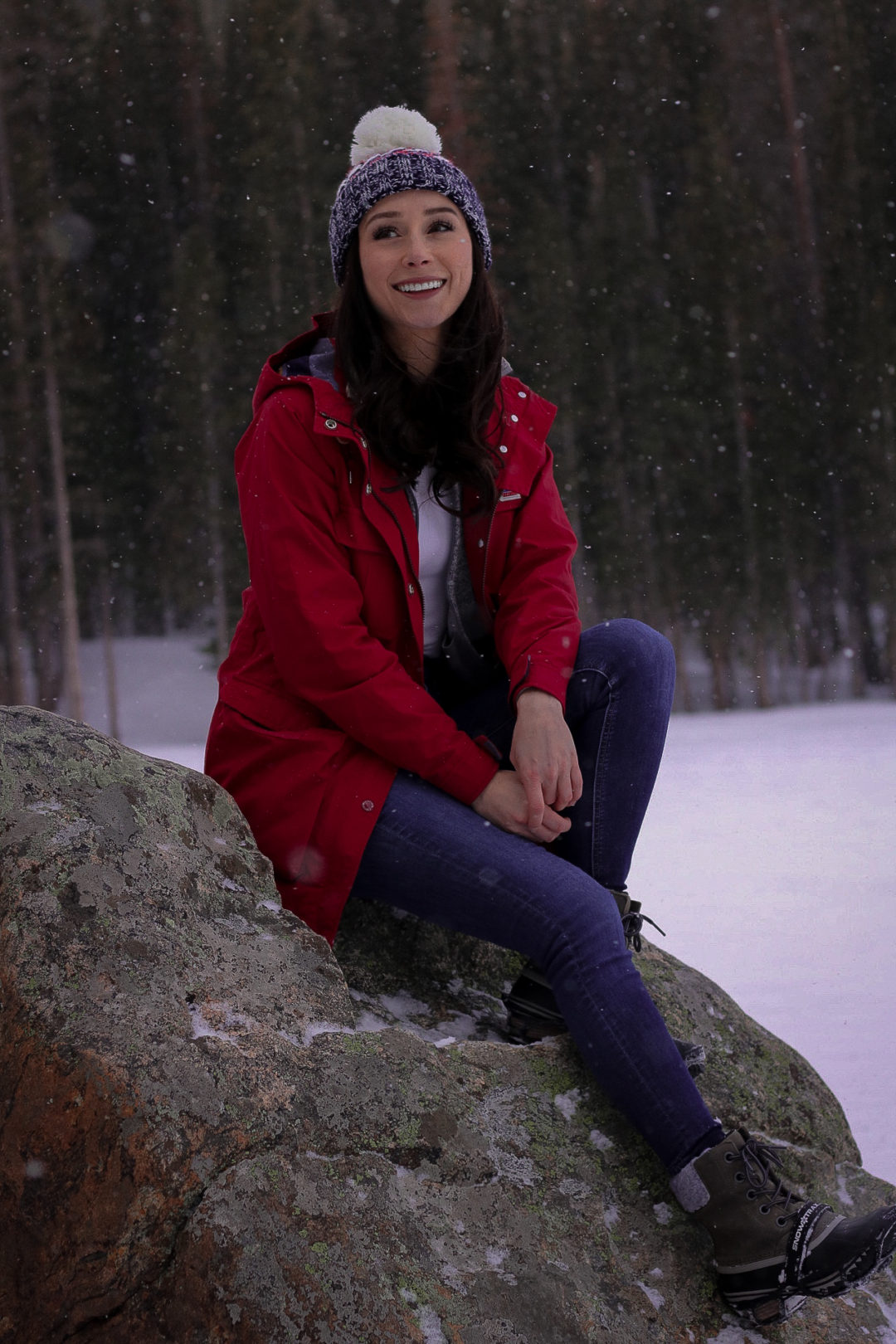 Travel Blogger Jordan Gassner sitting and smiling on a rock in Rocky Mountain State Park near Boulder, Colorado