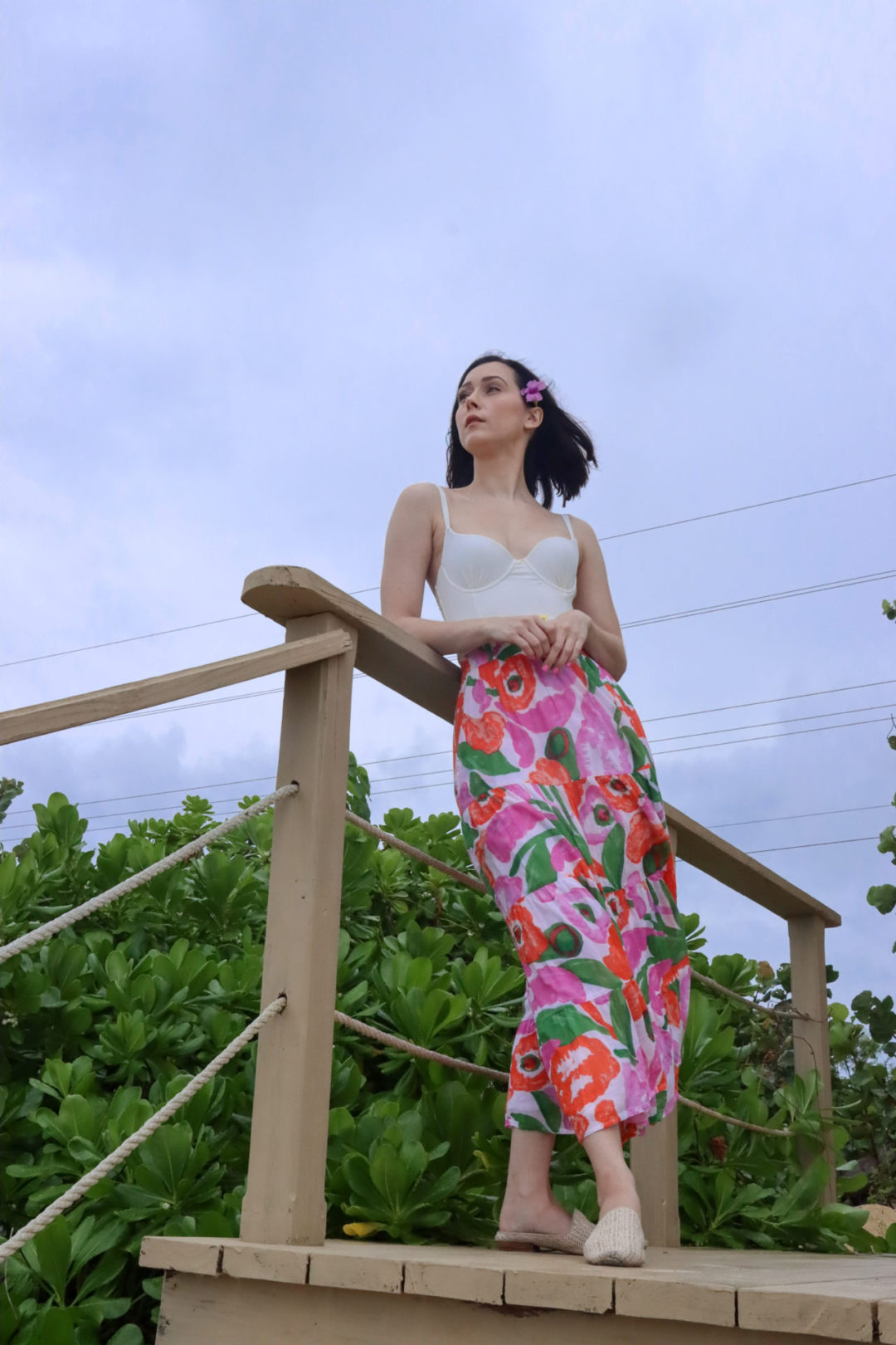 A Low angle photo of Travel Blogger Jordan Gassner leaning against a pier and staring out onto the ocean on the North Side of Cayman Islands