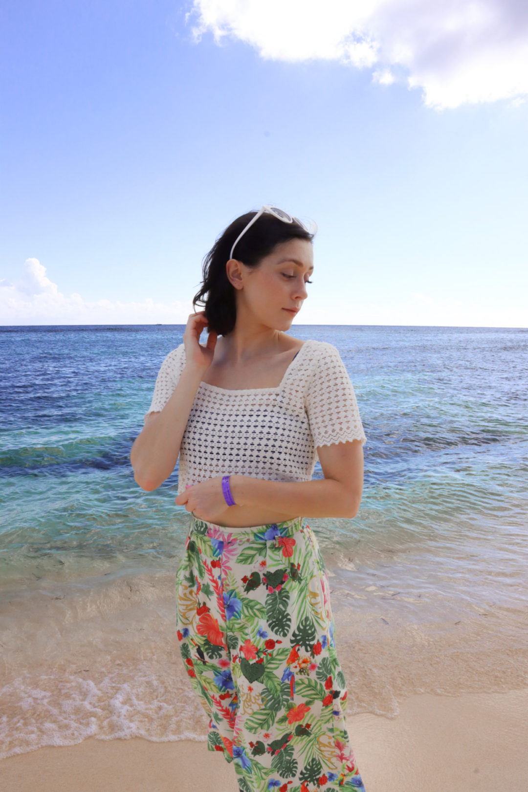 Travel Blogger Jordan Gassner looking over her shoulder by the water on Spotts Beach in the Cayman Islands