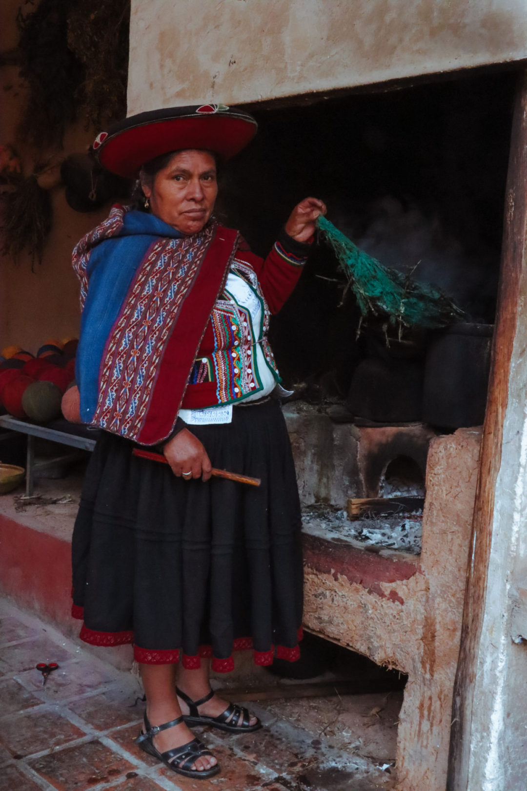 A Peruvian woman showing. howto traditionally dye fabric at El Centro De Textiles Tradicionales Del Cusco in Chinchero, Peru