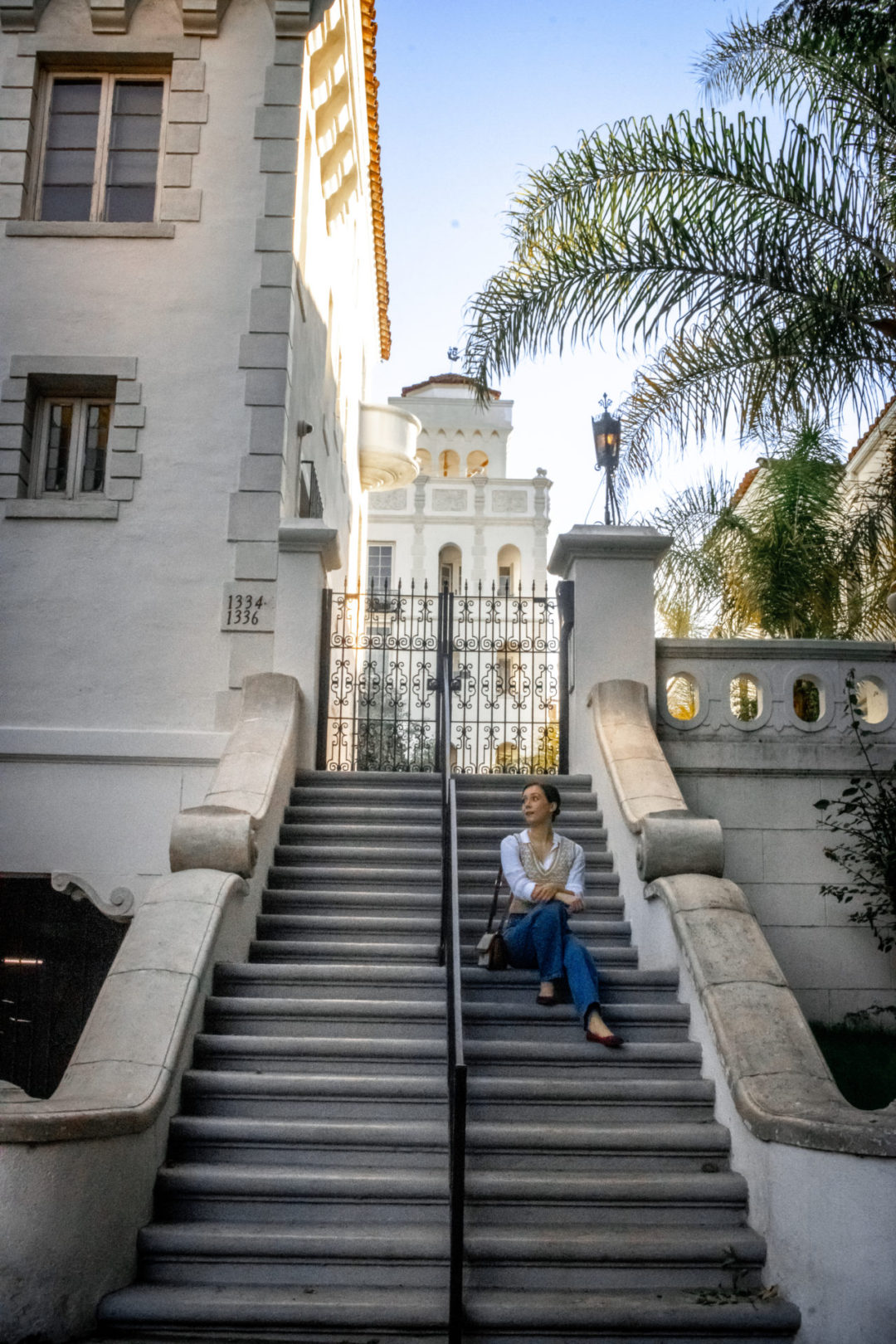 West Hollywood Walking Tour: Travel Blogger Jordan Gassner sitting on the staircase leading up to the historic Casa Granada