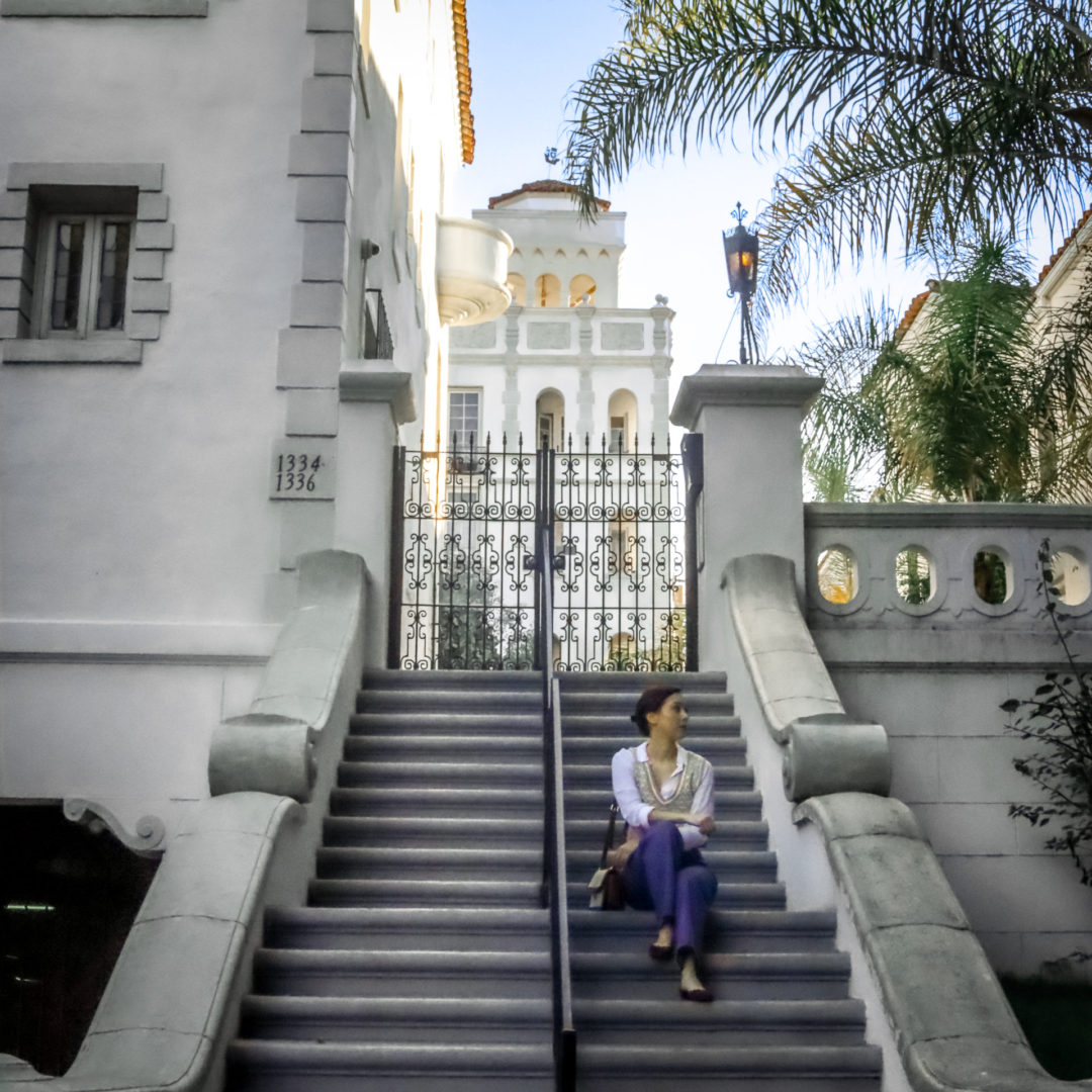 Travel Blogger Jordan Gassner looking off to the right from the staircase leading up to the historic Casa Granada in West Hollywood