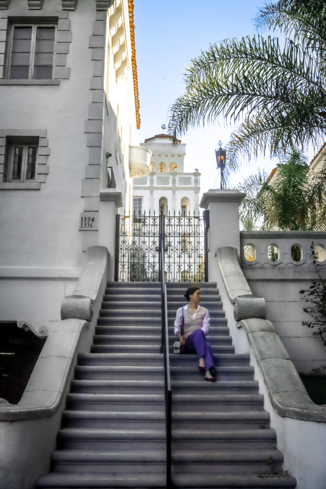 Travel Blogger Jordan Gassner sitting on the steps in front the historic Casa Granada Property in West Hollywood, California