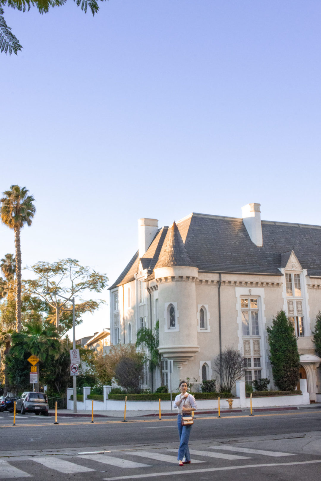 Travel Blogger Jordan Gassner walking through a crosswalk in front of the Four Gables building in West Hollywood, California