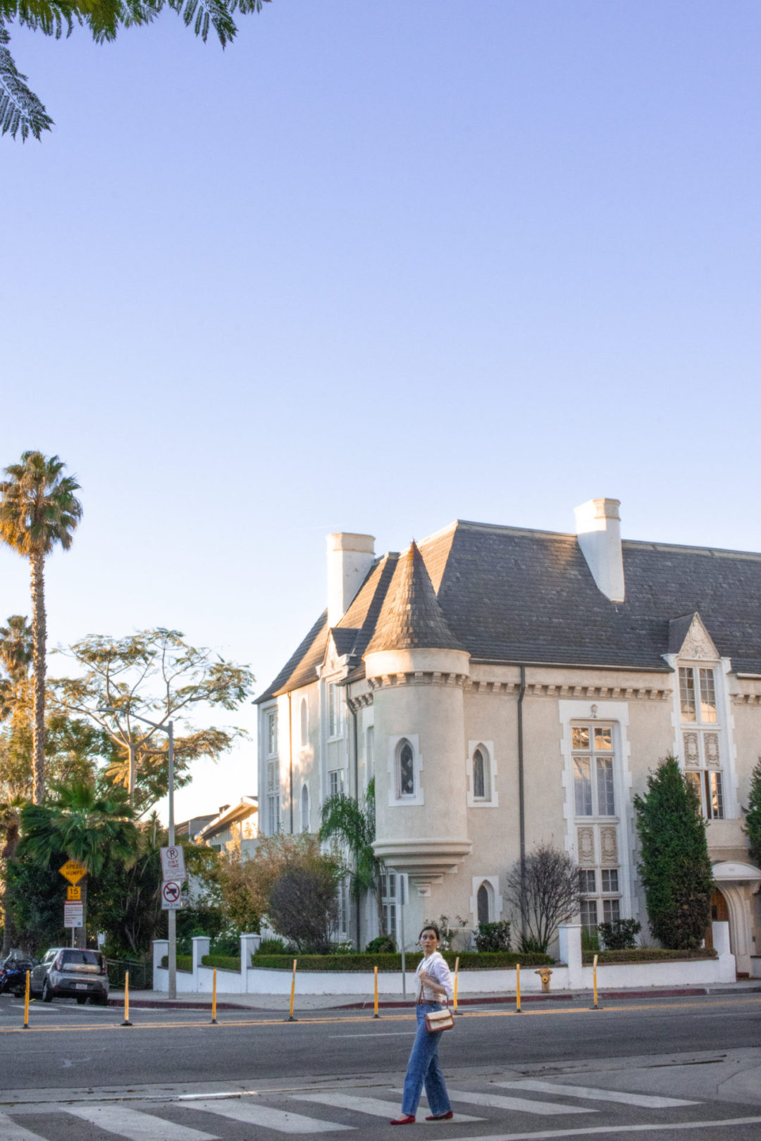 Travel Blogger Jordan Gassner walking through a crosswalk in front of the Four Gables building in West Hollywood, California