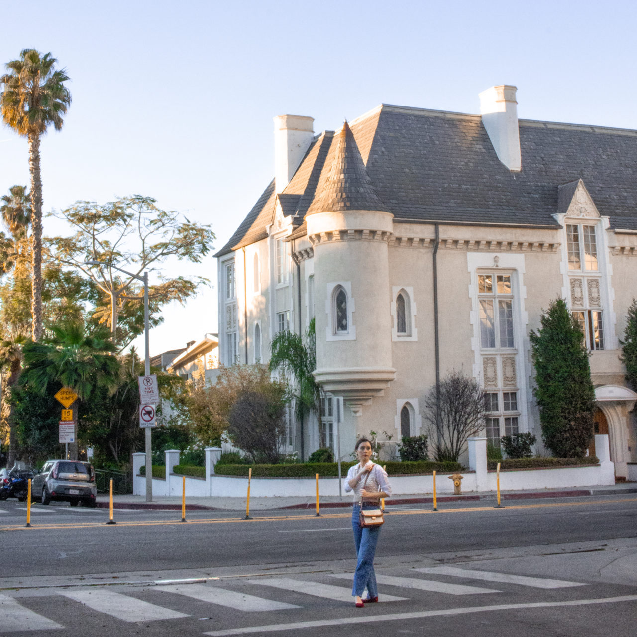 Travel Blogger Jordan Gassner holding her purse while standing in front of the Four Gables building in West Hollywood, California