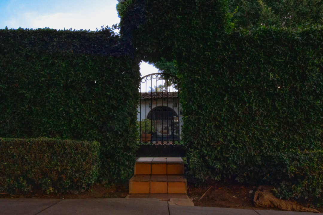 The gate and garden hedge leading up to Villa Primavera in West Hollywood, California