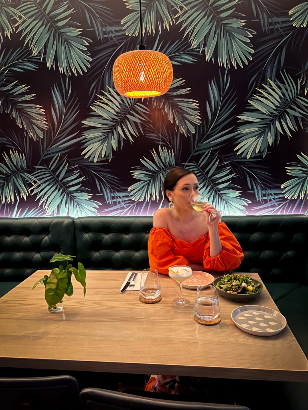 Travel Blogger Jordan Gassner drinking wine at a table inside Bayside Restaurant in Cayman Islands