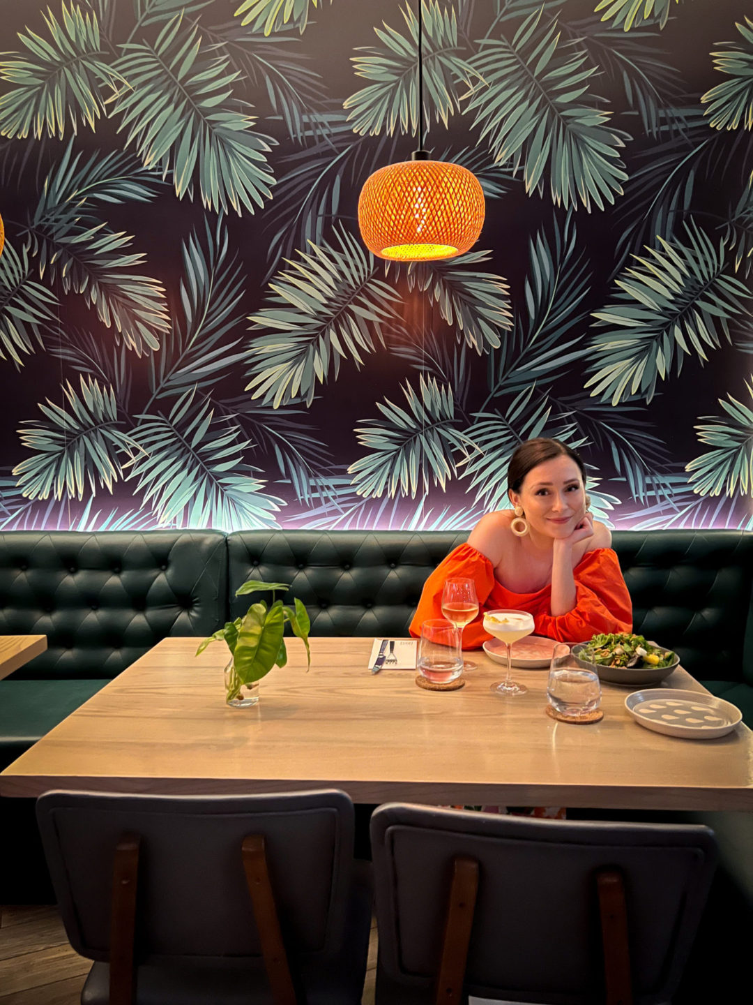 Travel Blogger Jordan Gassner smiling with her head in her hands at a table inside Bayside Restaurant on Grand Cayman Island