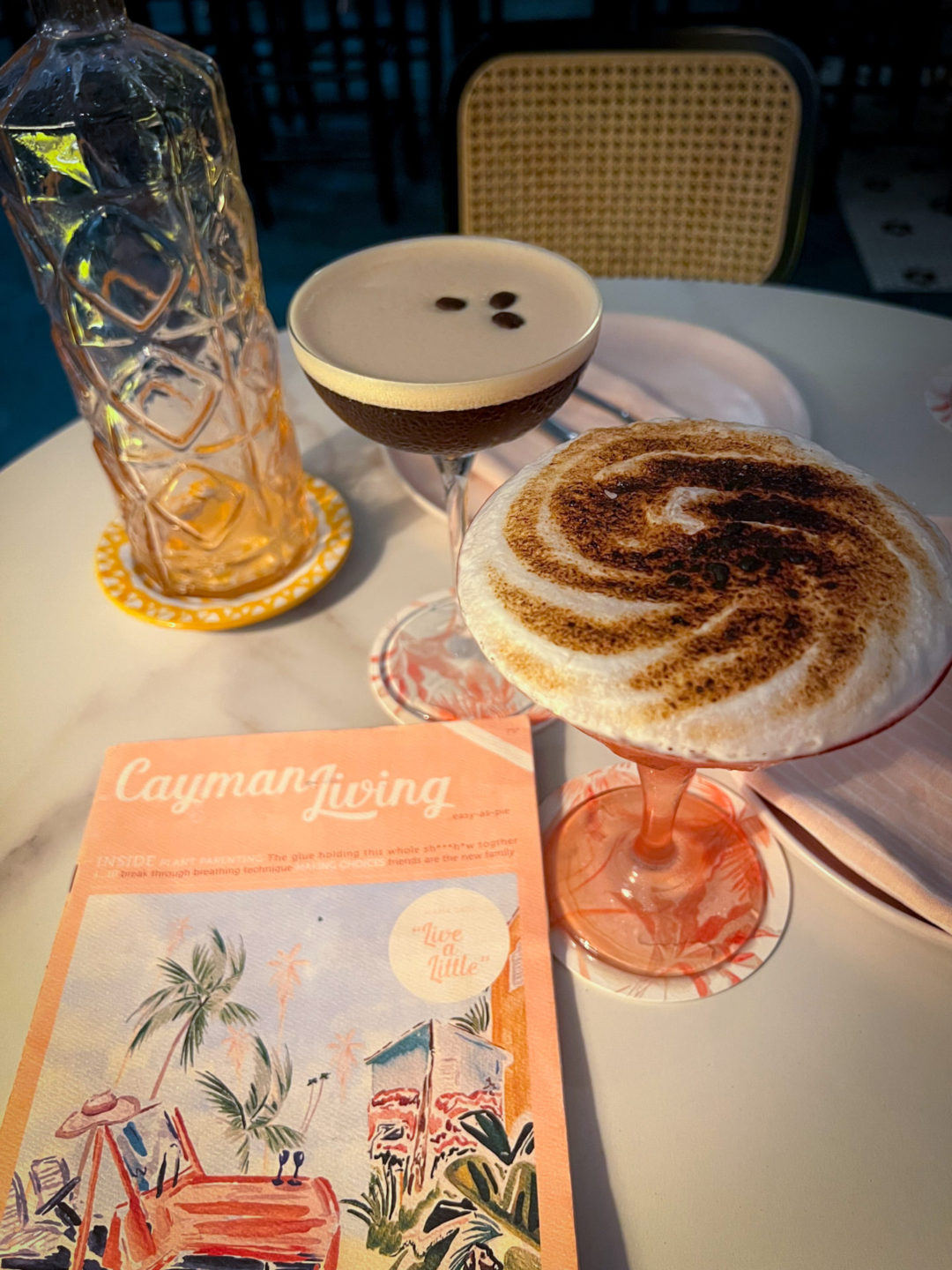 An espresso martini and the Celia Cruz cocktail next to a pink menu at the Ms. Piper's restaurant in Cayman Islands