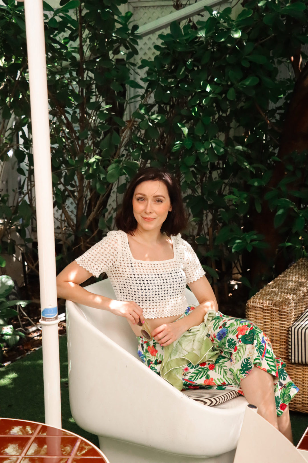 Travel Blogger Jordan Gassner smiling at camera while sitting in an egg shaped chair at Paradise Pizza in Cayman Islands