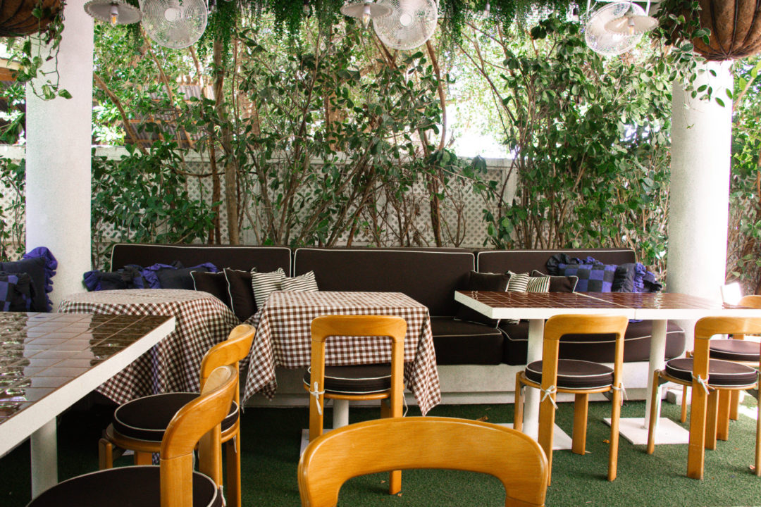 A series of white tables with brown tiles or brown and white checked table cloths at the back of Palm Heights' Paradise Pizza Restaurant