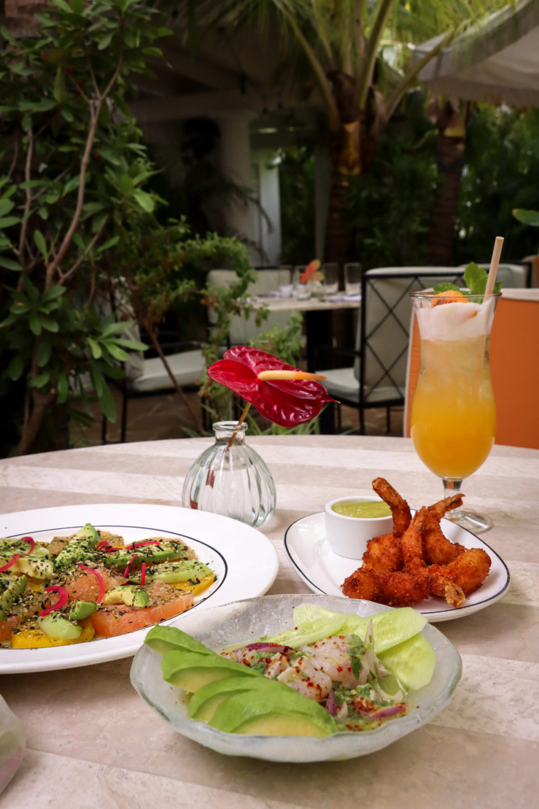 Citrus Salad, Aguachile Ceviche and Coconut Shrimp next to the Tillie's Branded Cocktail at Tillie's Restaurant in Cayman Islands