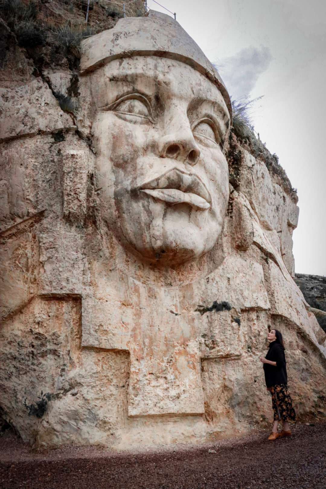 Travel Blogger Jordan Gassner looking up at the Pachamama sculpture at Apukunaq Tianen near Cusco, Peru