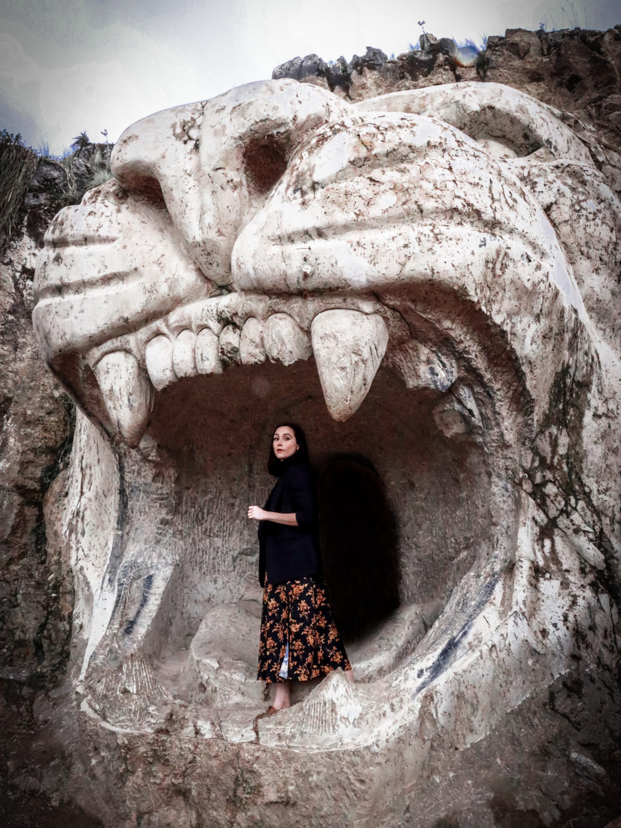 Travel Blogger Jordan Gassner standing in the mouth of the giant Puma sculpture at Apukunaq Tianen near Cusco, Peru