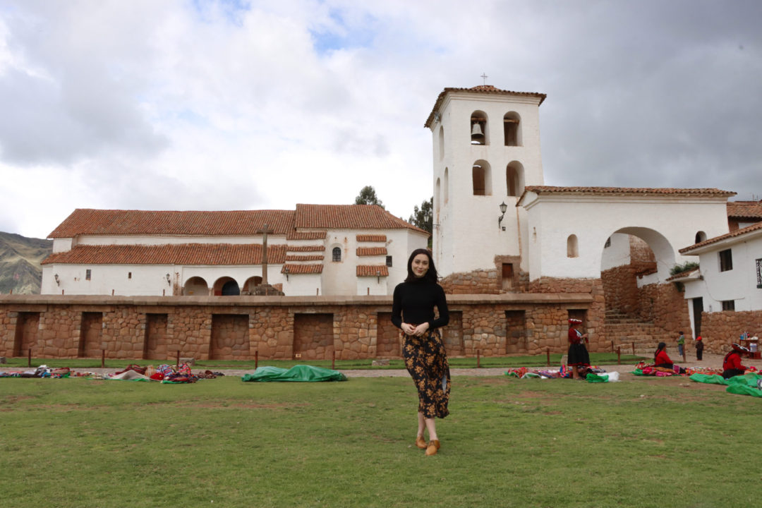 Travel Blogger Jordan Gassner standing in the middle of Antigua Plaza de Chinchero in Peru's Sacred Valley after a rainstorm 
