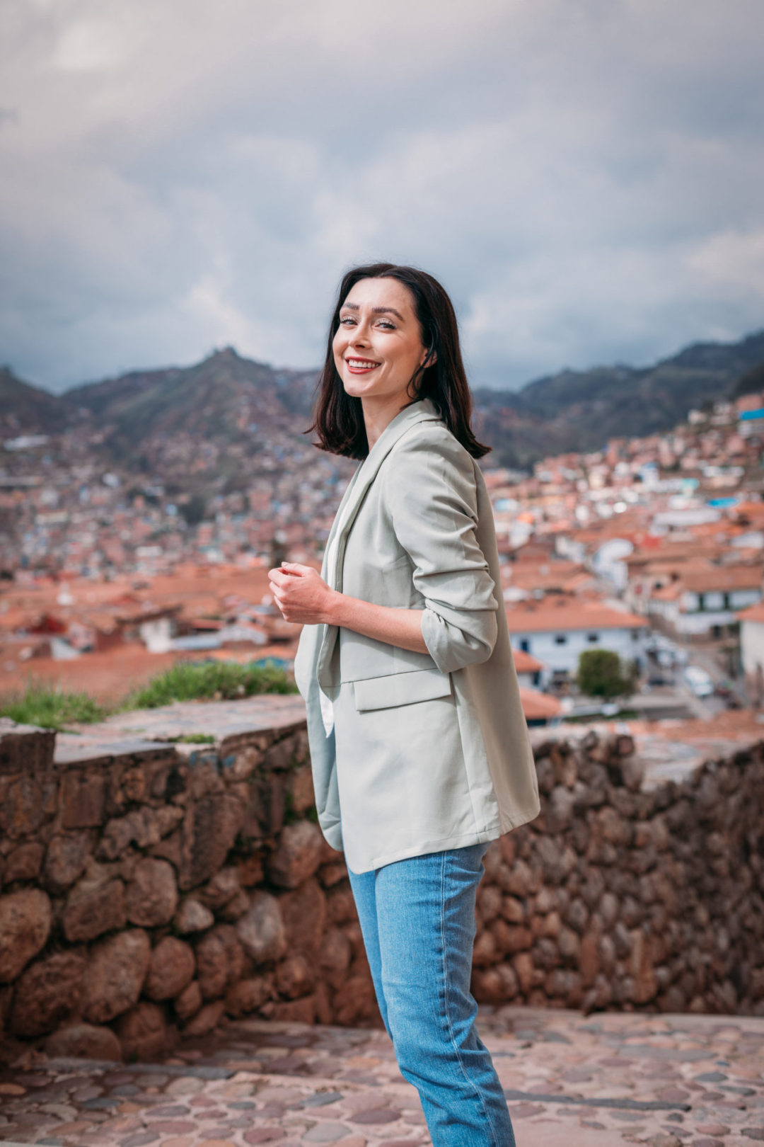 Travel Blogger Jordan Gassner smiling toward camera on Calle Waynapata overlooking Cusco's Plaza De Armas