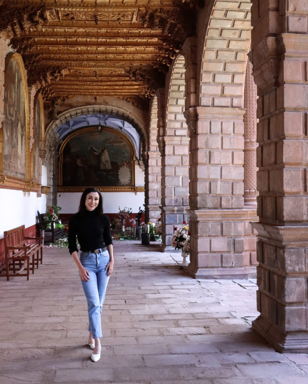 Travel Blogger Jordan Gassner standing under one of the many porticoes inside Cusco, Peru's Convento La Merced 