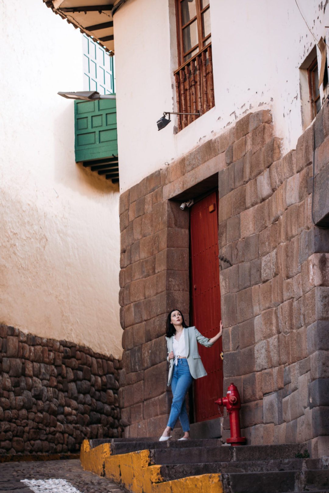 Travel Blogger Jordan Gassner looking up a at a red door in Córdoba del Tucumán - one of the most beautiful places in Cusco