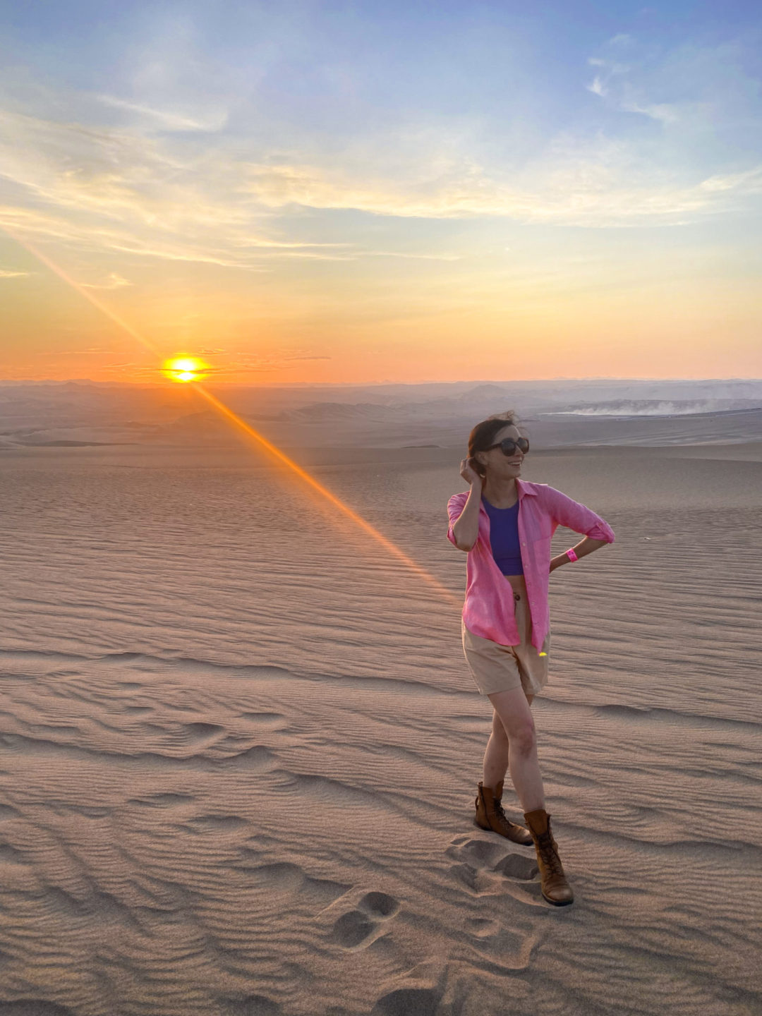 Lima Travel Guide: Travel Blogger Jordan Gassner standing on endless sand on a dune at sunset near Huacachina in Peru