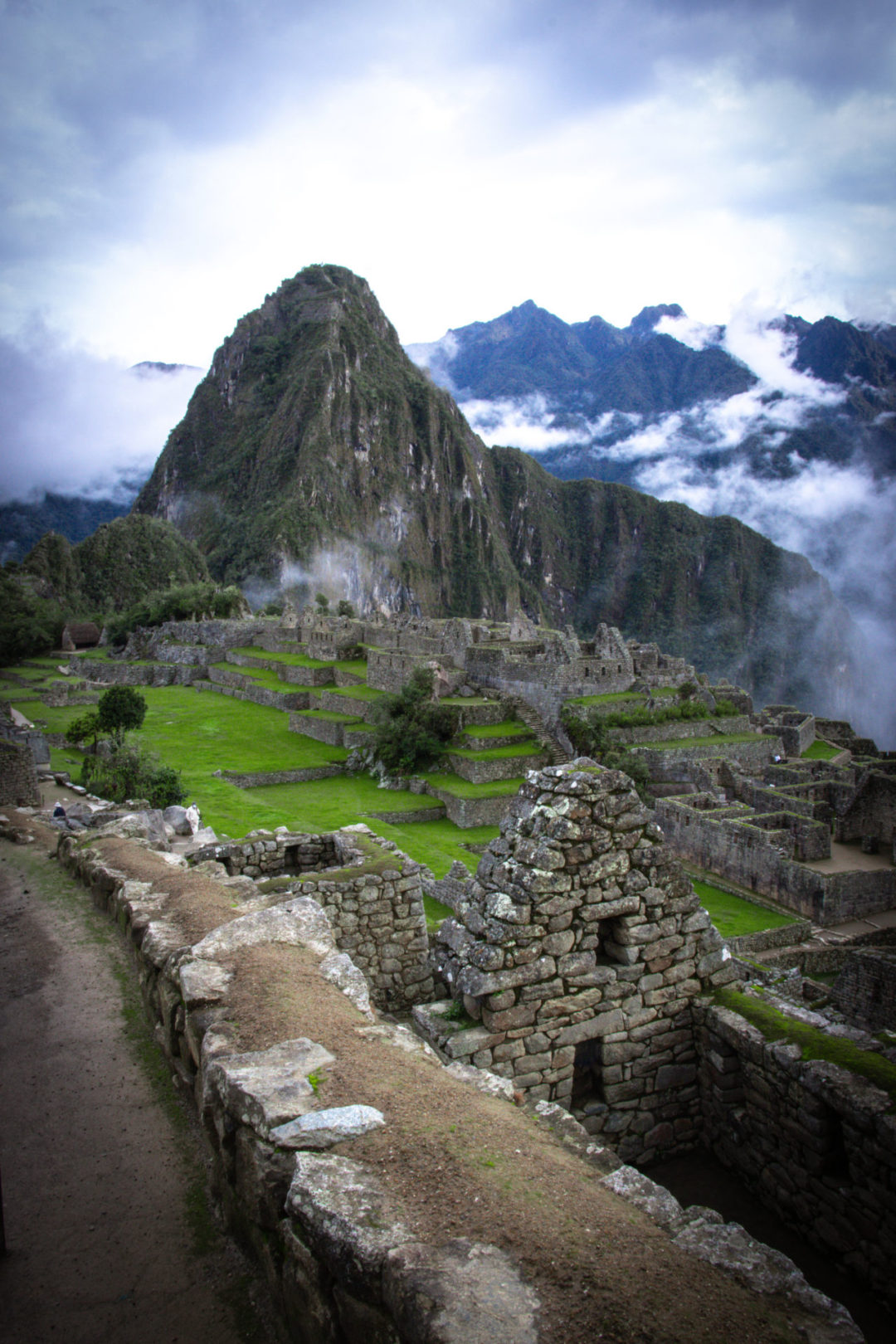 Machu Picchu By Train: Huayna Picchu overlooking the city of Machu Picchu in Peru