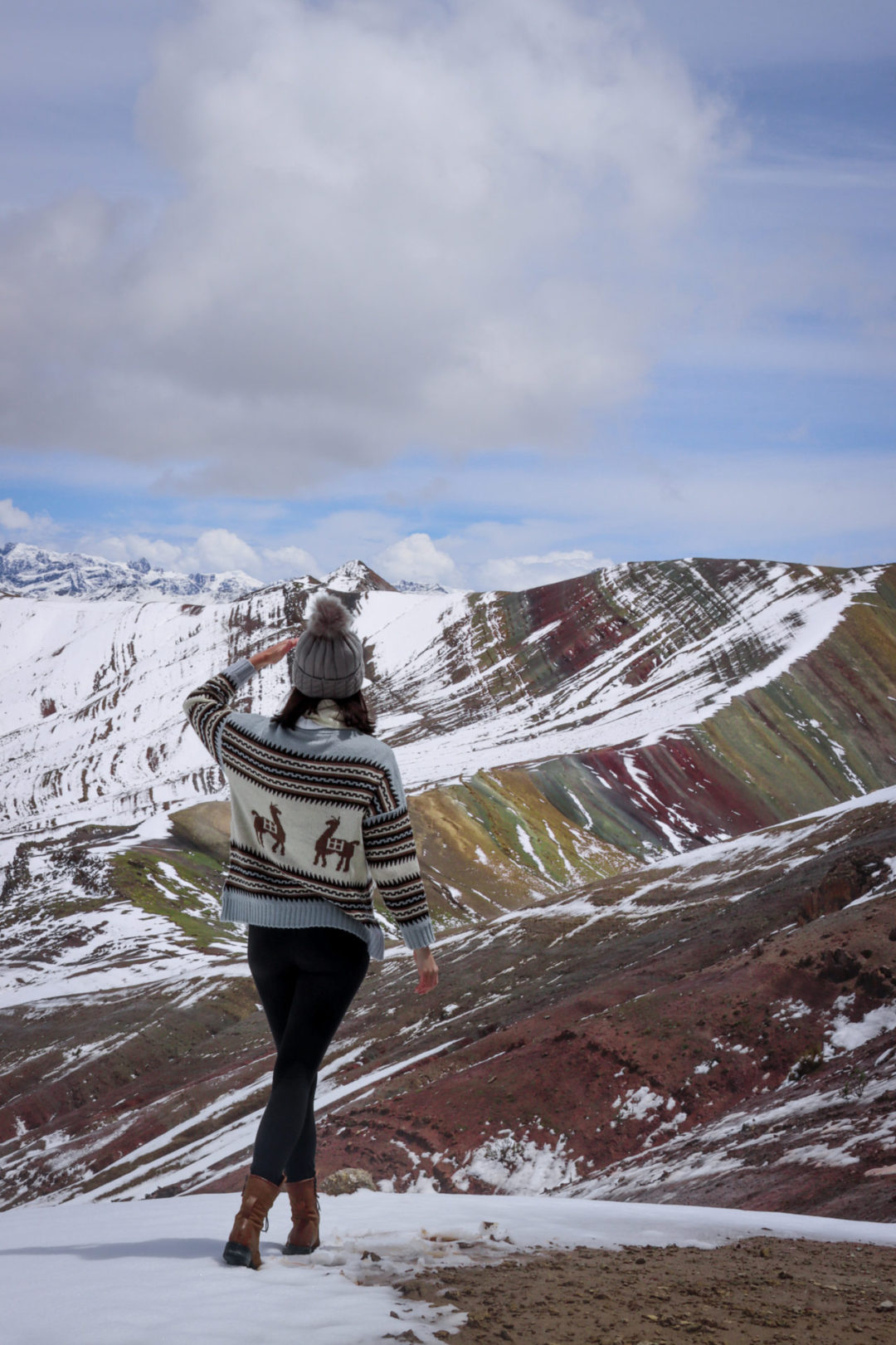 Travel Blogger Jordan Gassner looking out at the colors at the top of the Palccoyo Rainbow Mountain