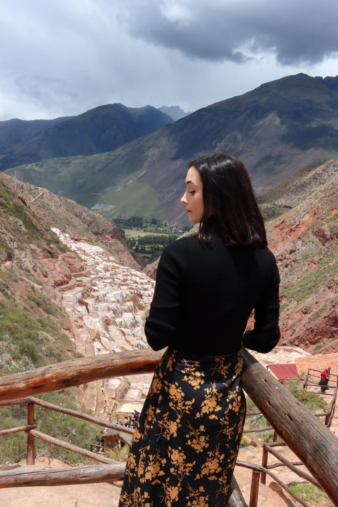 Travel Blogger Jordan Gassner looking down while at. arail overlooking Salinas De Maras in Peru