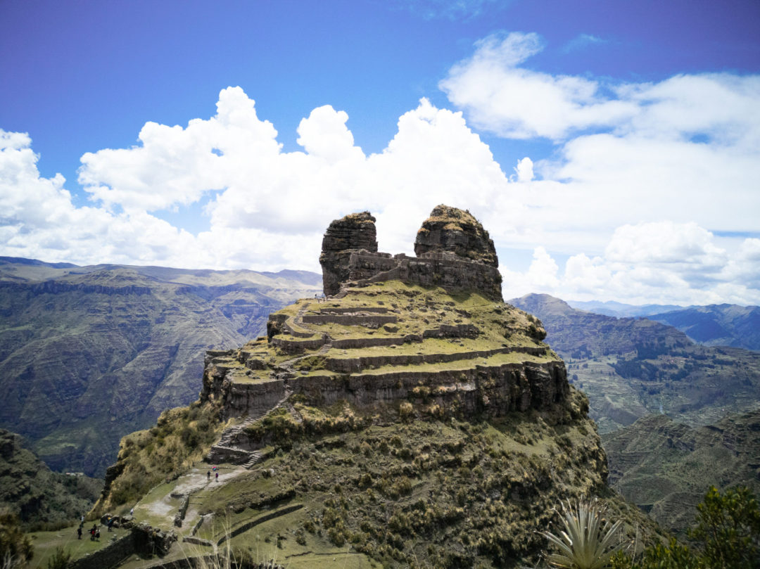 Waqrapukara, the ancient Inca fortress of Cusco, Peru jutting up from the top of a mountain into a blue sky