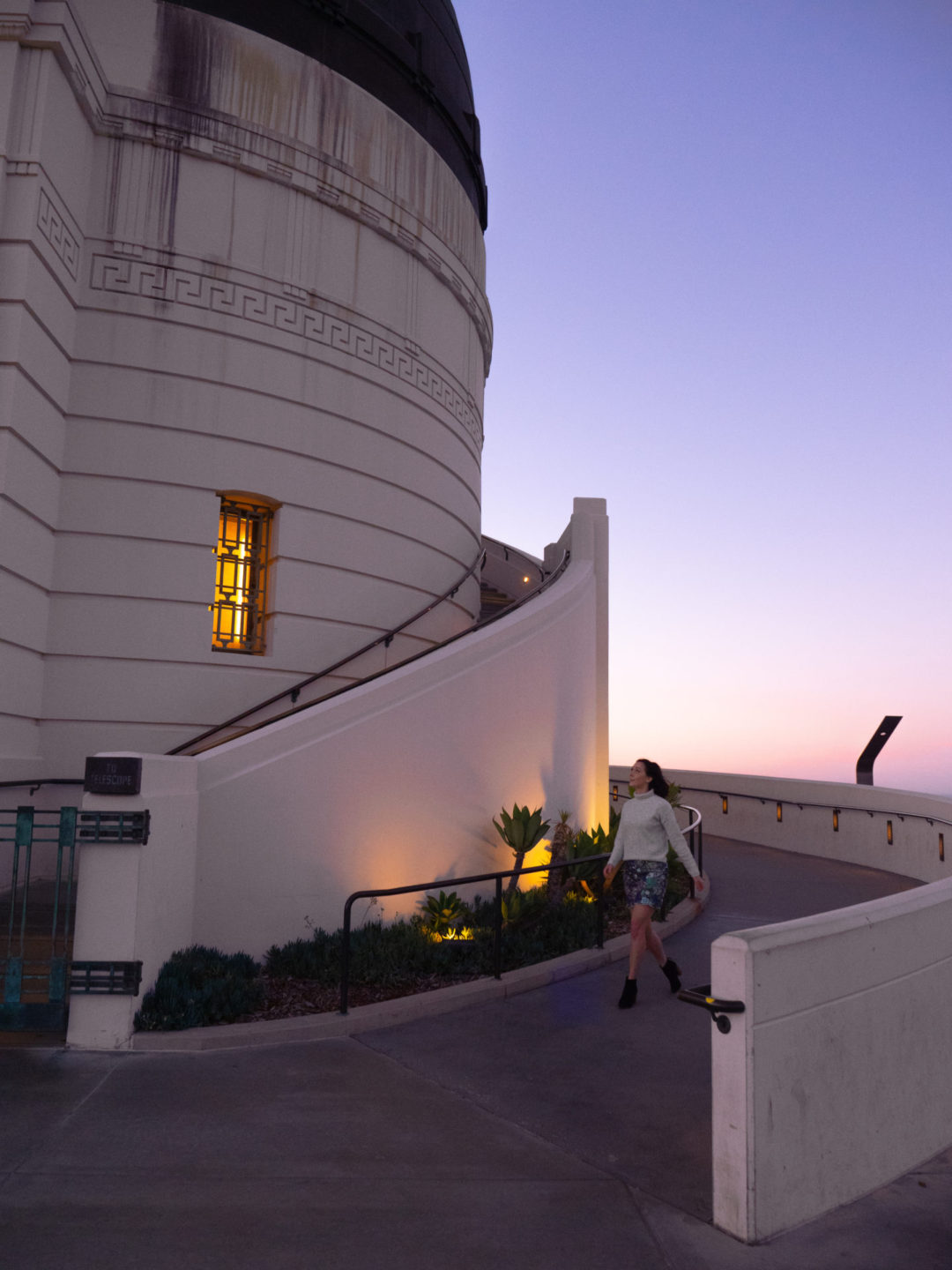 Travel Blogger Jordan Gassner walking down the ramp alongside Griffith Observatory's western rotunda in Los Angeles, California