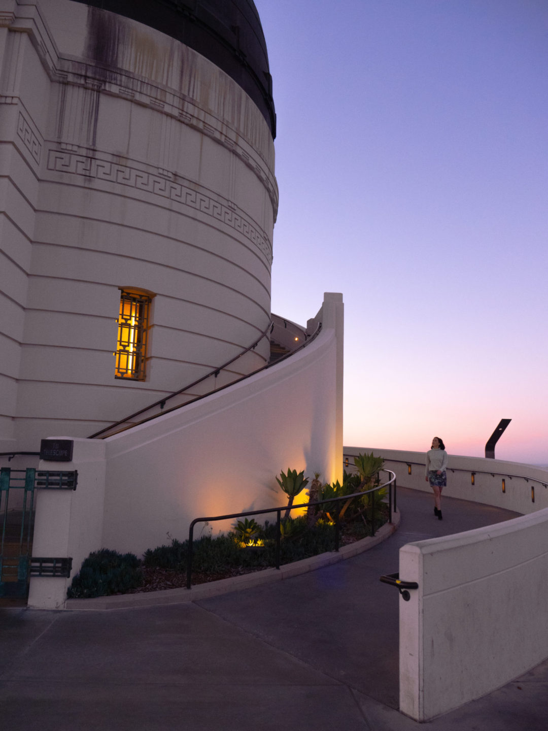 Travel Blogger Jordan Gassner rounding the corner of the ramp alongside Griffith Observatory's western rotunda in Los Angeles