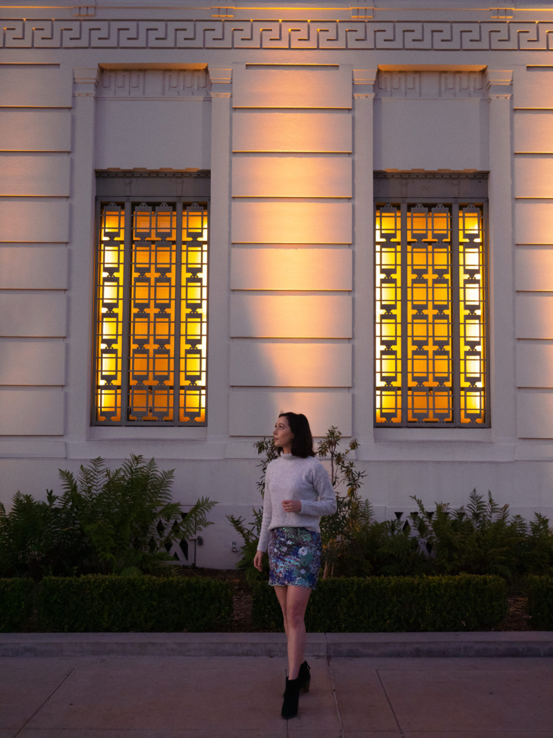 Travel Blogger Jordan Gassner in front of the front wall of Griffith Observatory in Los Angeles