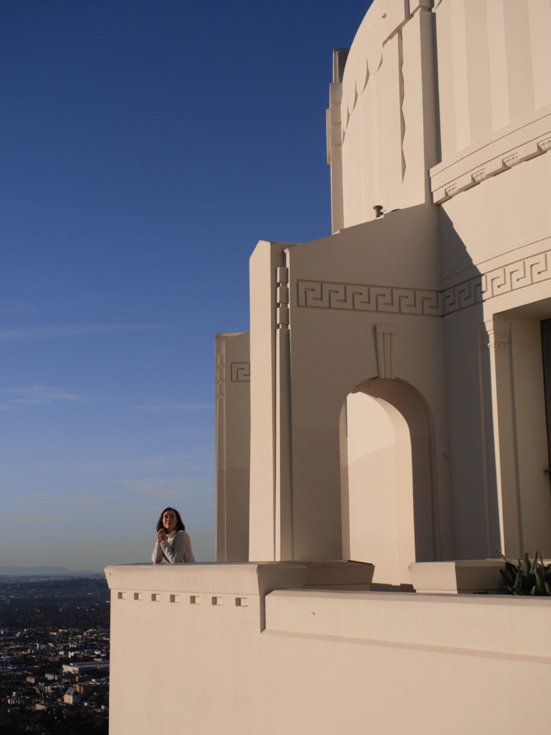 Travel Blogger Jordan Gassner looking out over LA from the back archway of Griffith Observatory in Southern California