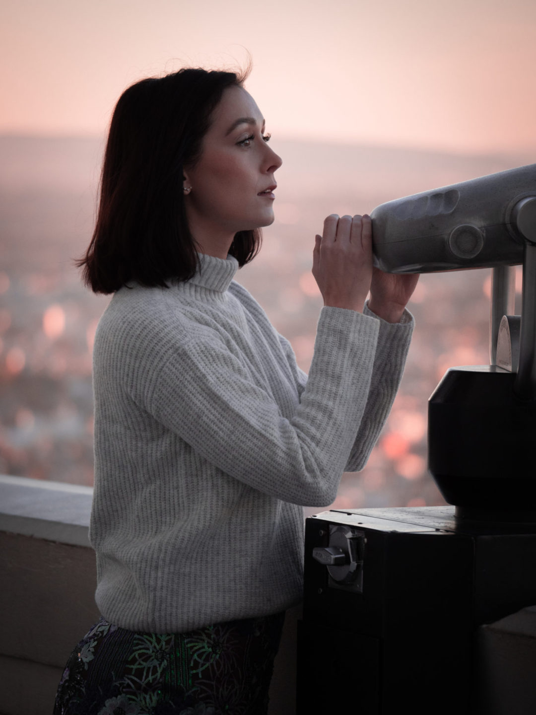 Travel Blogger Jordan Gassner looking over a tower viewer at the Griffith Observatory in Los Angeles, California in the United States
