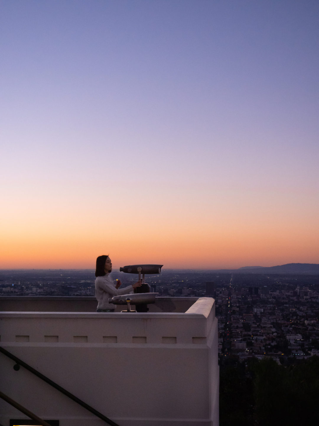 Travel Blogger Jordan Gassner looking out over Los Angeles from a viewpoint at Griffith Observatory one of the La La Land filming locations in Los Angeles, California