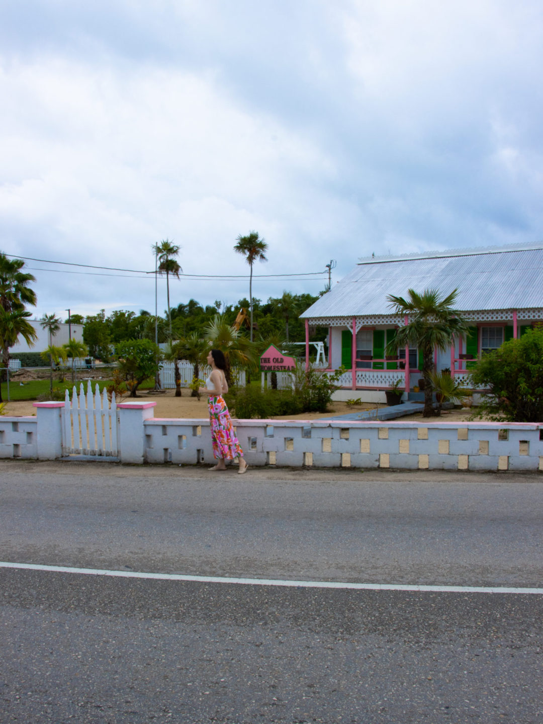 Travel Blogger Jordan Gassner walking along the road in front of "The Old Homestead" in Cayman Islands