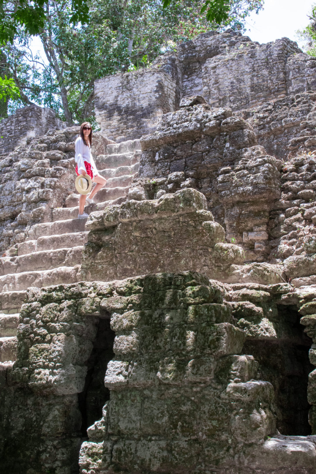 Travel Blogger Jordan Gassner standing on a few of the steep stairs leading up a structure inside Tikal National Park in Guatemala