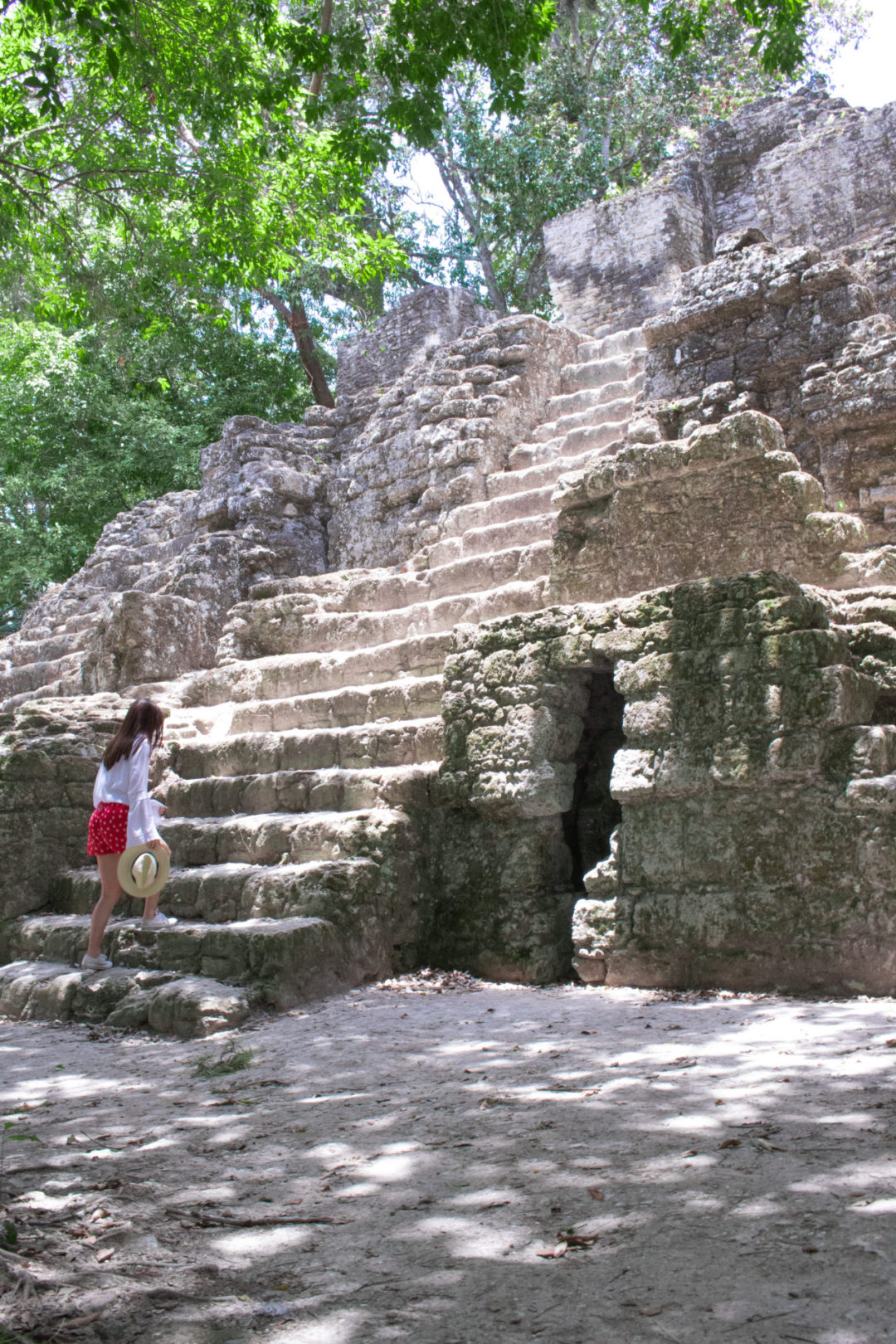 Travel Blogger Jordan Gassner climbing up a set of stairs on a Mayan pyramid in Guatemala's Tikal National Park