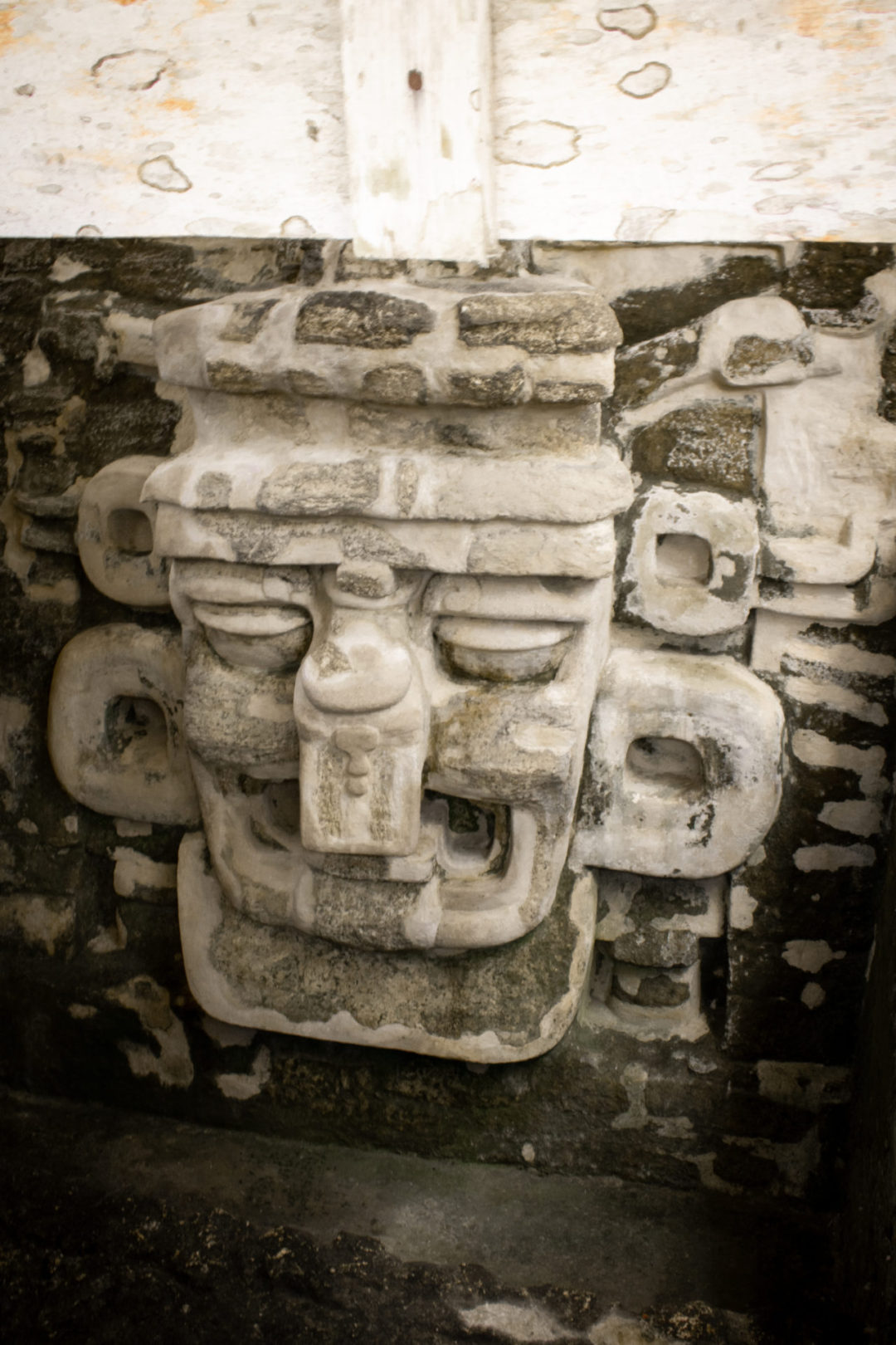 A giant carved face made of stone inside Tikal National Park in Guatemala