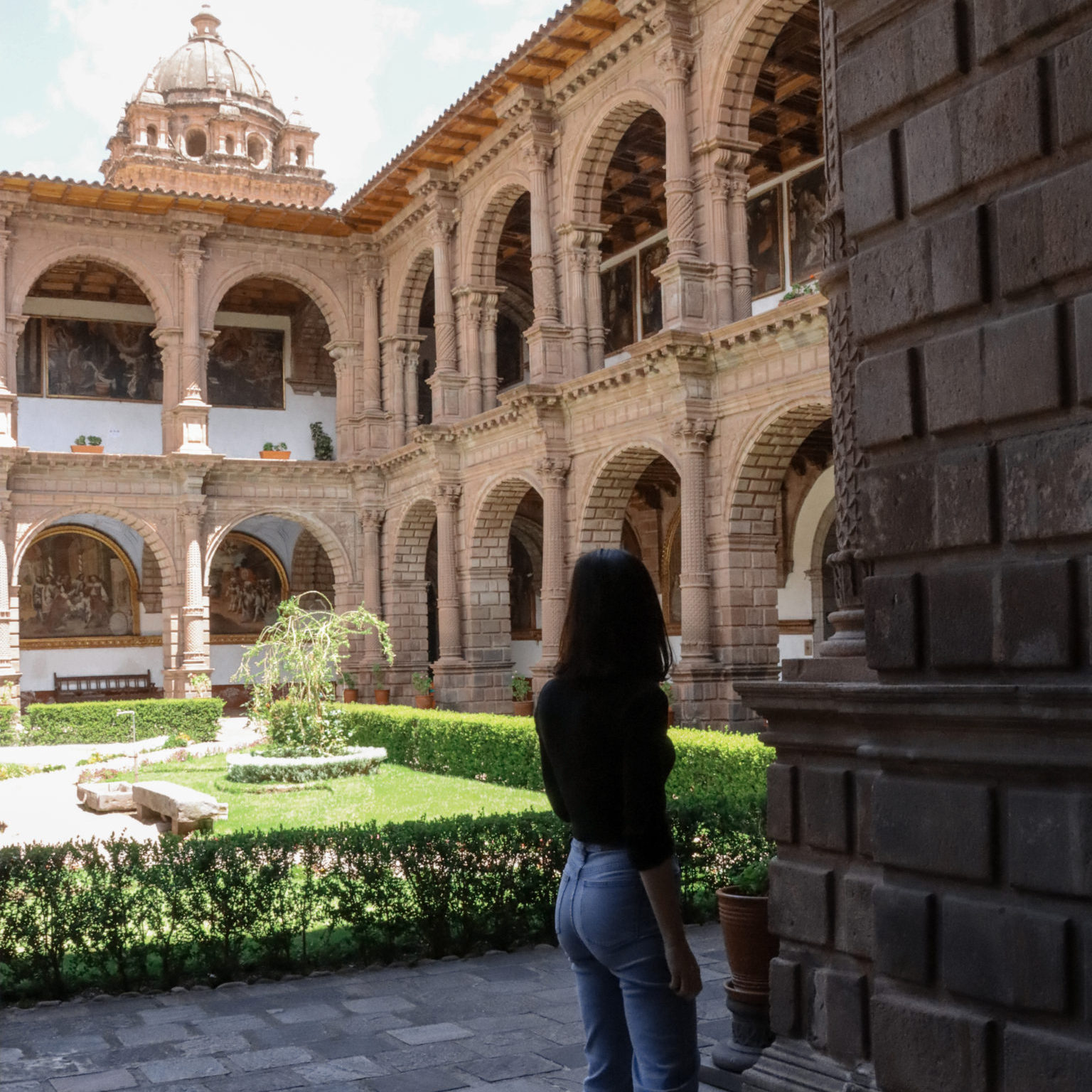 Travel Blogger Jordan Gassner standing in the shade and looking out toward the center courtyard in Cusco, Peru