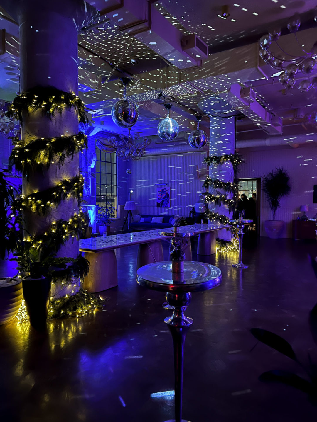 Blue and pink lights, discoballs and lit up garland adorning the Heimat Club coworking space for their annual New Year's Eve Party