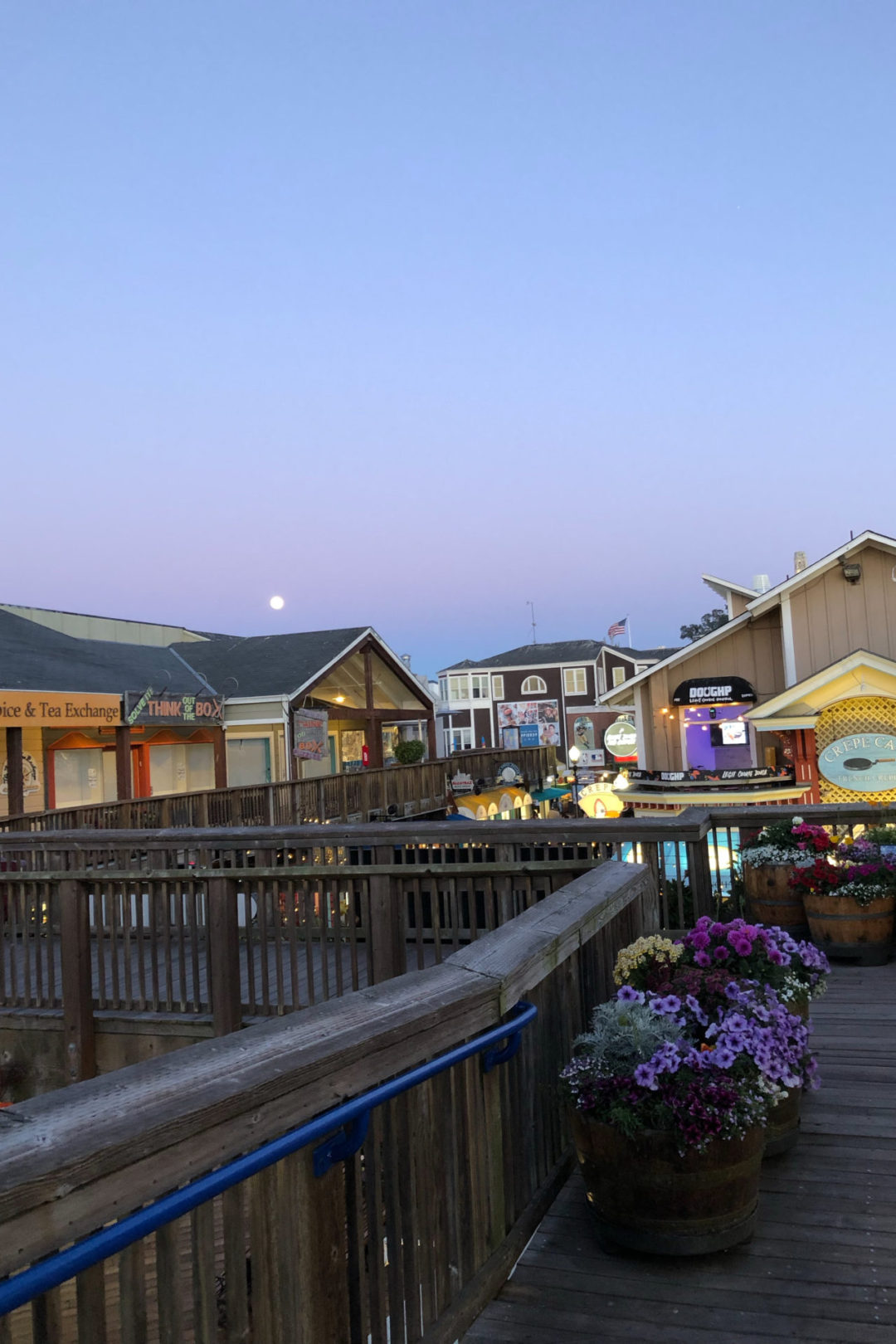 An empty second floor walkway at Pier 39 in San Francisco under a purple sunset