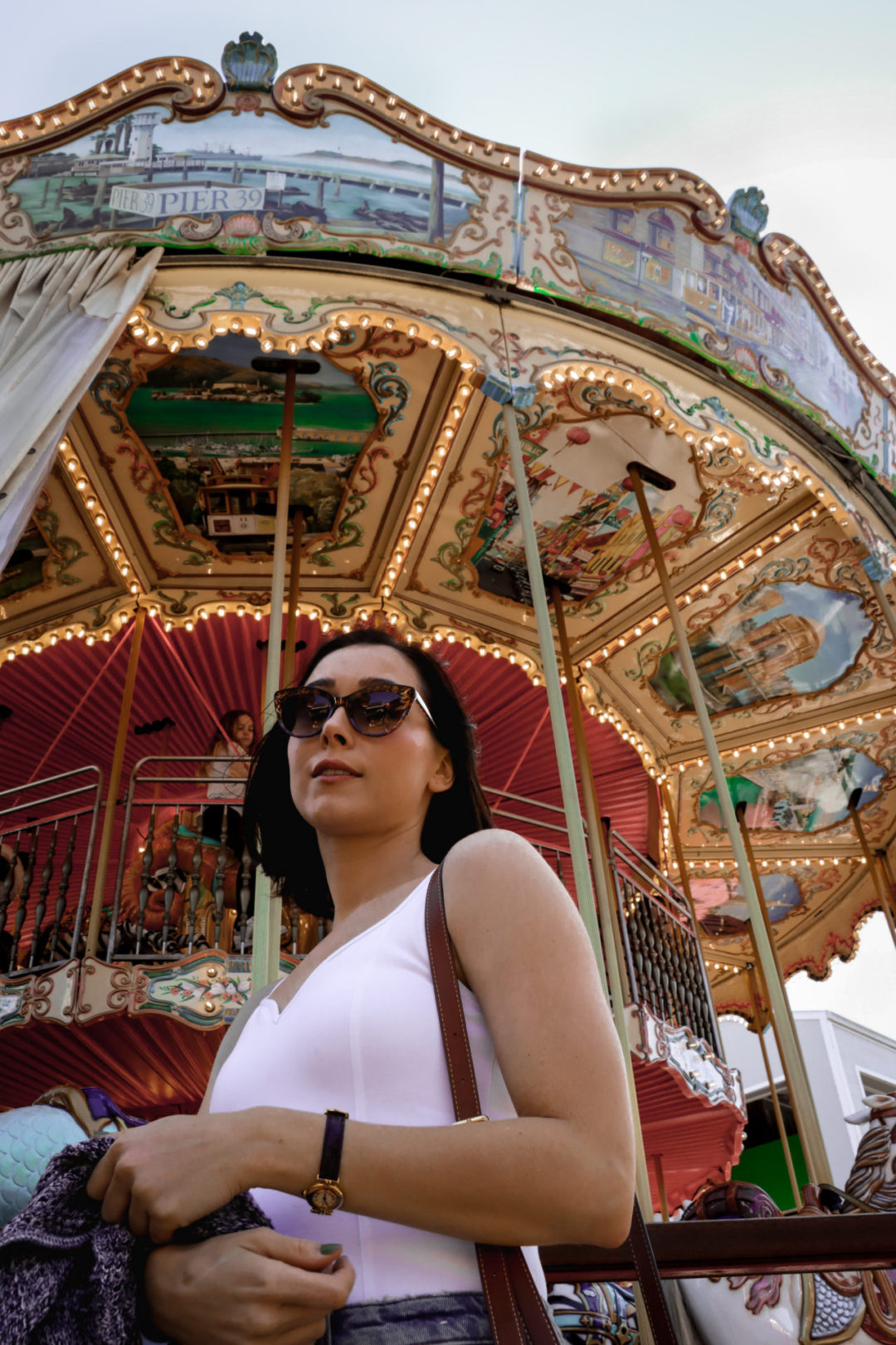 Travel Blogger Jordan Gassner standing in front of the carousel at Pier 39 in San Francisco