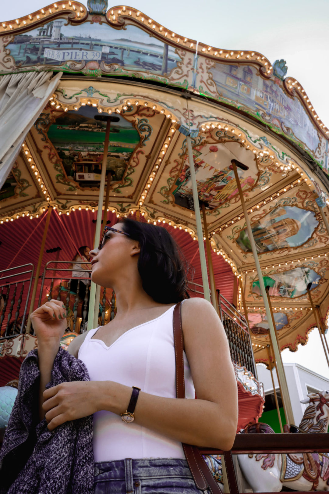 Travel Blogger Jordan Gassner looking back at the carousel at Pier 39 in San Francisco