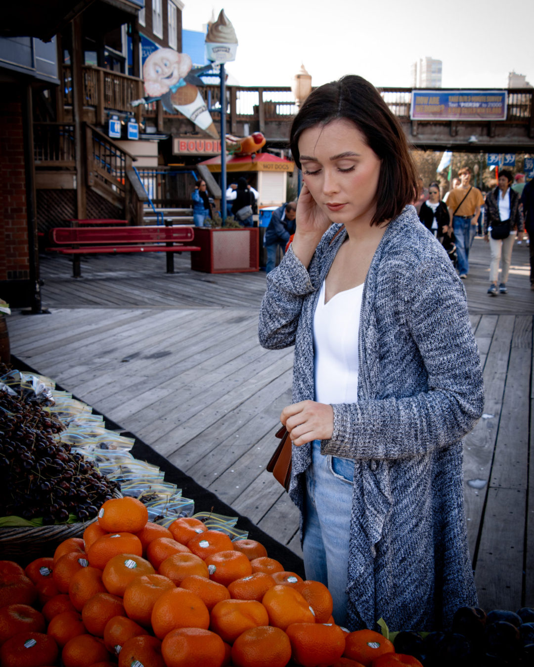 Travel Blogger Jordan Gassner looking at a group of oranges at a fruit stand in San Francisco Pier 39