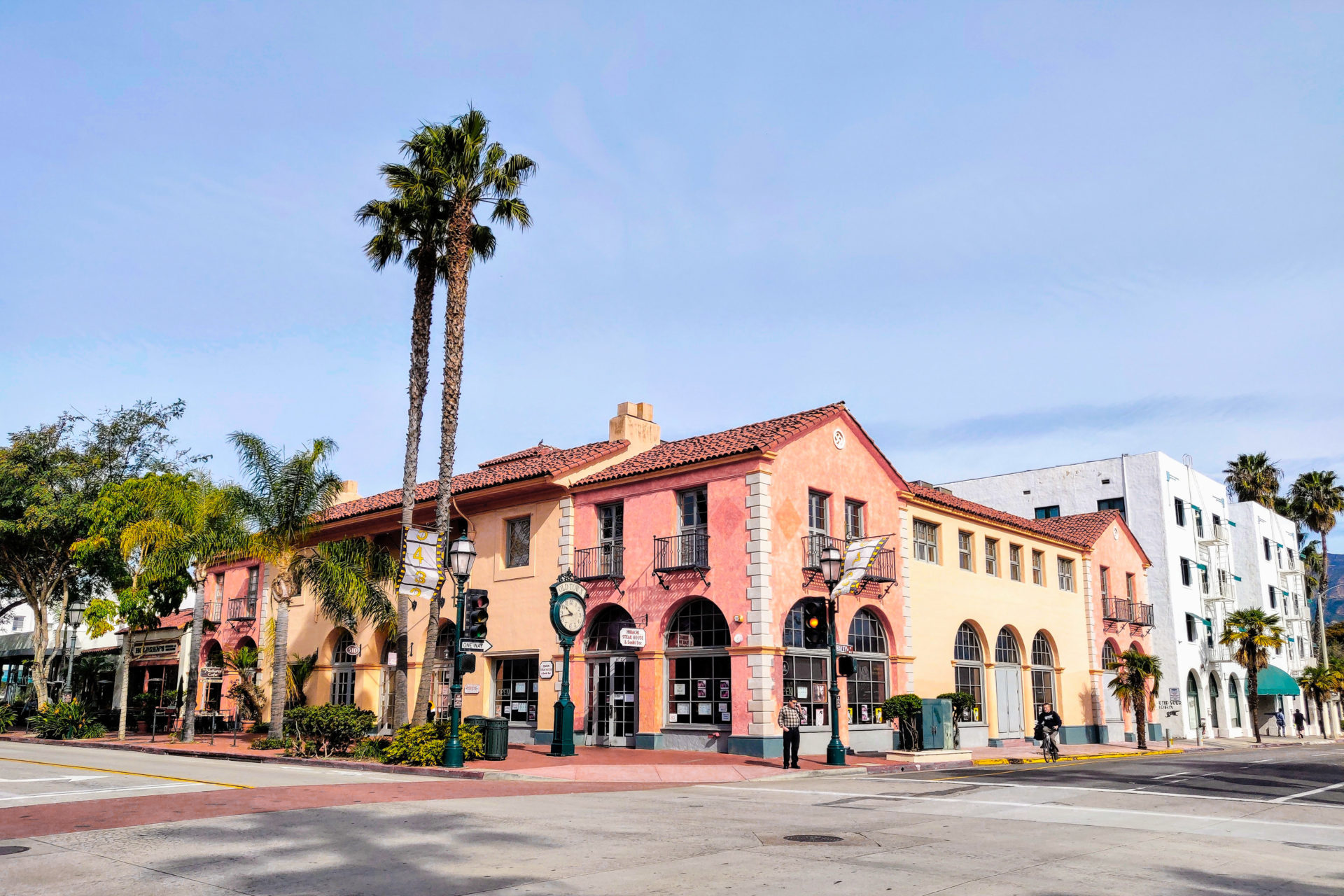Red, orange and yellow historic buildings near palm trees in Santa Barbara's downtown area