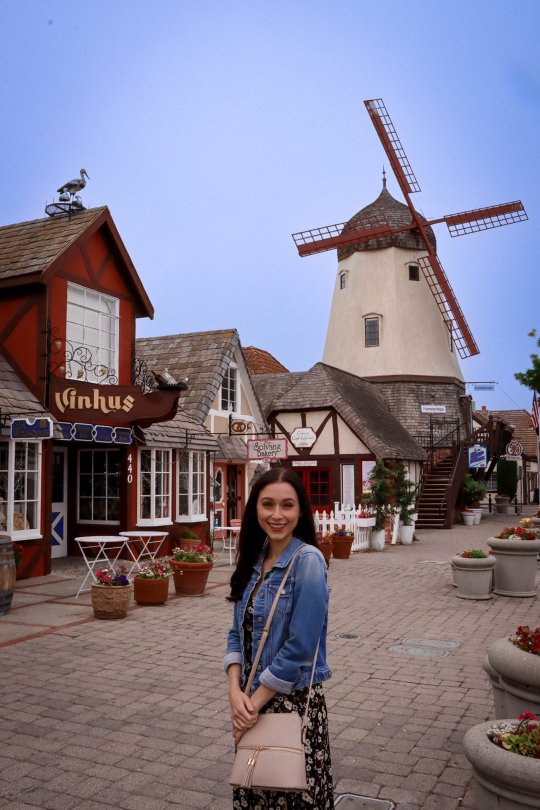 Travel Blogger Jordan Gassner standing and smiling on Alisal Road in front of Vinhaus in Solvang, California