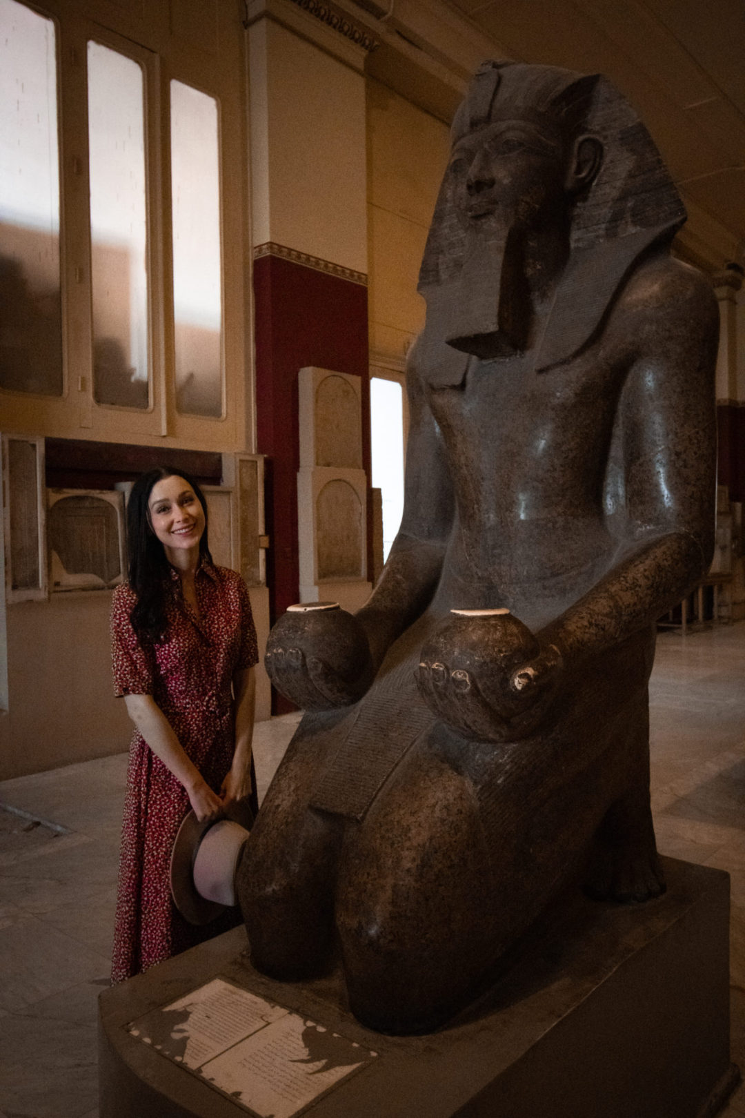 Travel Blogger Jordan Gassner smiling next to a statue of Pharaoh Hatshepsut inside the Museum of Antiquities in Cairo
